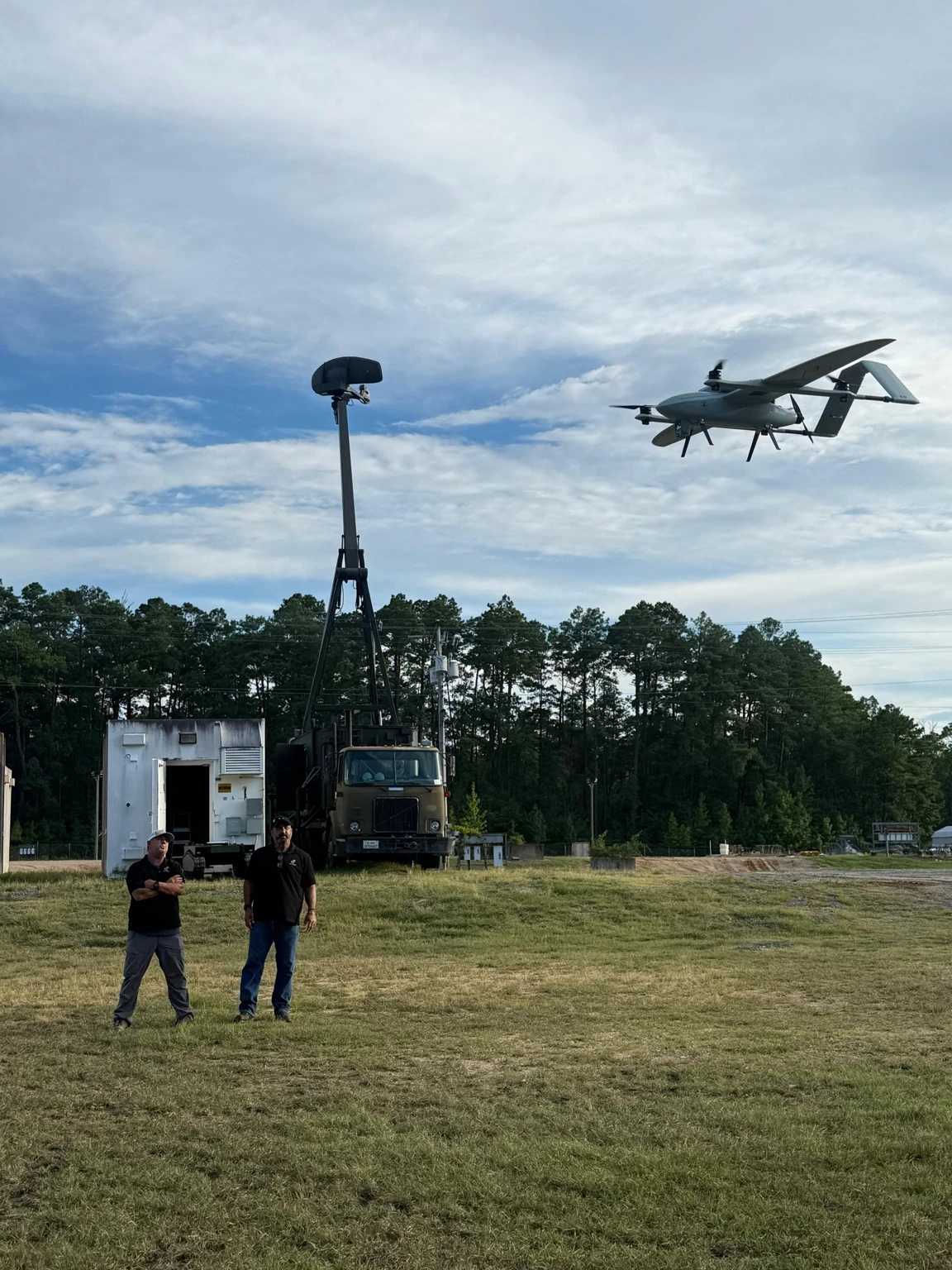 ORKID 260 in VTOL flight near a mast and field personnel